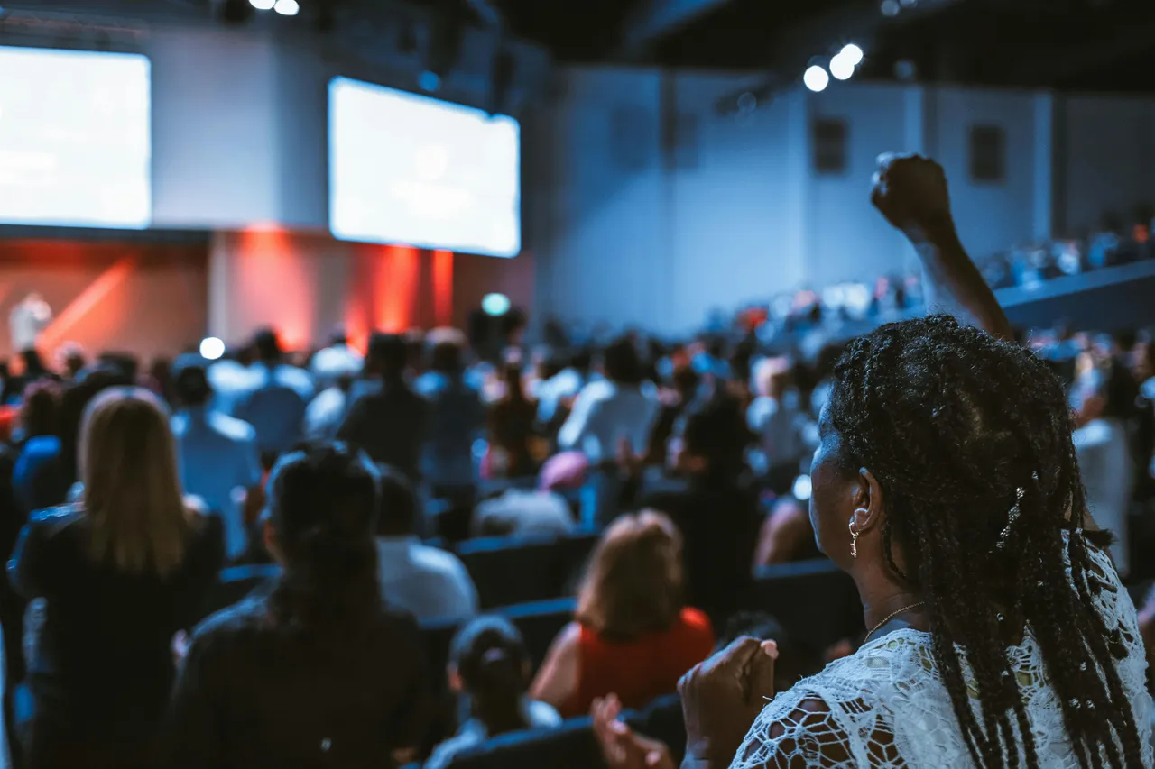lady in crowd with raised hand