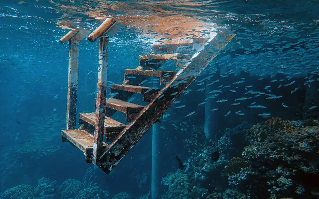 decrepit staircase leading down to a coral reef
