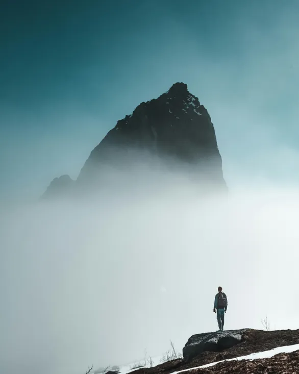 man gazing upon a fog shrouded precipice