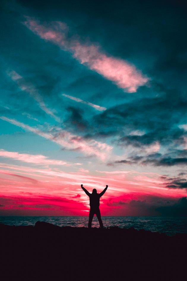 triumphant man in front of sunset
