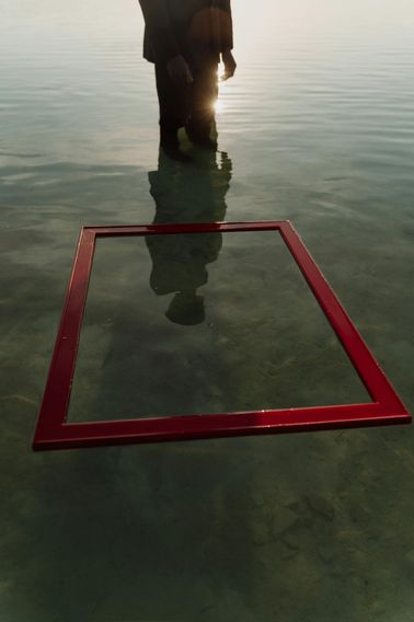 person looking at reflection of self in water